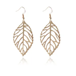 Macro view of golden hollow leaf earrings with intricate metallic vein patterns