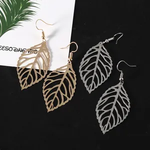 Detailed view of hollow leaf earrings in gold and silver finishes with hook wires