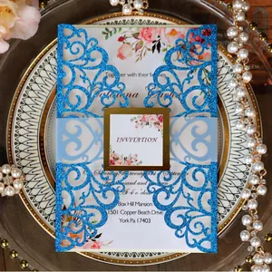 Elegant laser-cut blue glitter wedding invitation set with floral card and gold-edged seal
