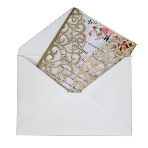 Elegant laser-cut gold glitter wedding invitation set with floral card and white envelope
