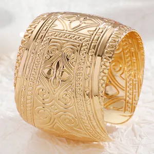 Detailed view of vintage gold-tone wide cuff bracelet with intricate embossed floral patterns