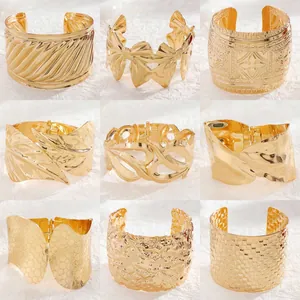 Collection of nine gold textured wide cuff bracelets in various geometric designs