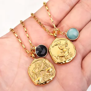 Gold stainless steel zodiac coin necklace with Libra and Scorpio pendants in palm