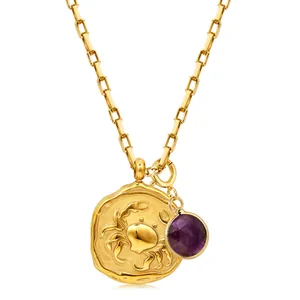 Detailed shot of gold Cancer zodiac coin pendant with a faceted purple gemstone