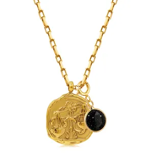 Detail of Libra zodiac coin pendant and black starstone on a gold rectangle link chain