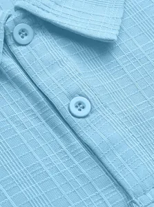 Close-up of light blue polo shirt featuring textured waffle fabric and buttons