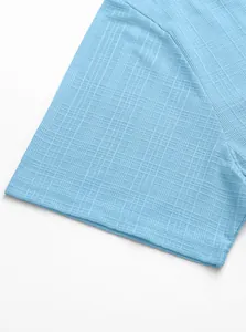 Close-up of light blue polo shirt fabric showing breathable micro-check woven texture