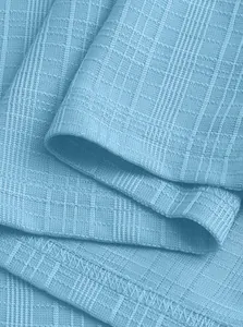 Detailed macro view of light blue small checkered knit fabric with refined stitching