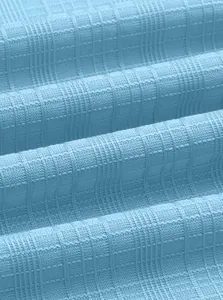 Macro shot of light blue polo shirt fabric showing soft knit waffle square textures