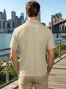 Rear view of a men's beige textured knit polo shirt with a city skyline background