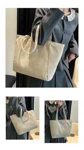 Detail of beige corduroy tote bag showing ribbed texture and fashion label