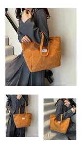 Detailed close-up of brown corduroy tote bag featuring a stitched FASHION label