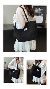 Detailed view of black corduroy tote bag showing large capacity and FASHION label