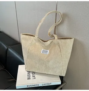 Detailed view of beige corduroy tote bag showing ribbed texture and FASHION label