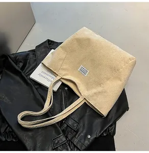 Macro shot of off-white corduroy tote bag texture with woven fashion label detail