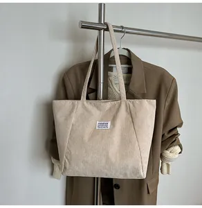 Close-up of the vintage corduroy tote bag detail showing the fashion label on cream fabric