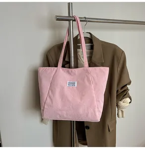 Detail of pink corduroy tote bag showing vertical texture and Fashion brand label