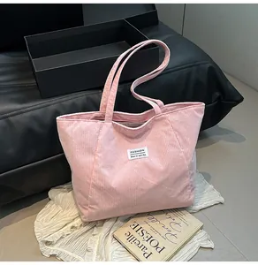 Pink corduroy tote bag detail showing the soft ribbed texture and fashion logo label