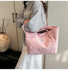 Detail of pink corduroy tote bag showing thick ribbed texture and Fashion label