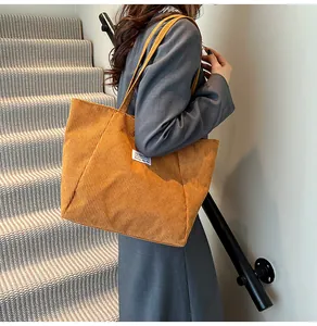 Detail of corduroy tote bag showing the textured fabric and fashion side label