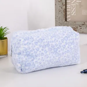 Detail shot of blue leopard print plush cosmetic bag featuring soft faux fur texture