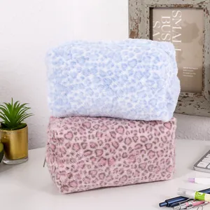 Close-up of pink and blue leopard print plush cosmetic bags with metal zippers
