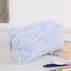 Detailed macro of the blue leopard print plush cosmetic bag with a metal zipper