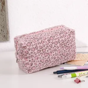 Detailed macro view of pink leopard heart print plush makeup bag with silver metal zipper