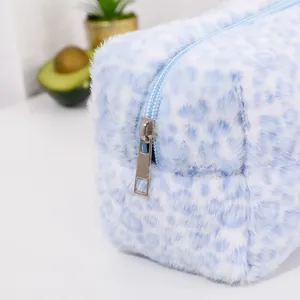 Close-up of soft plush leopard print cosmetic bag showing zip detail and texture
