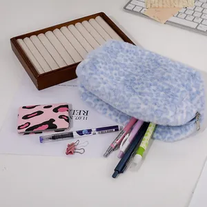 Detailed macro view of soft blue leopard plush makeup bag with smooth metal zipper
