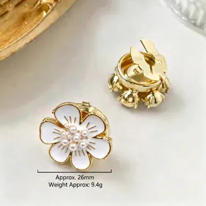 Detailed macro view of a 26mm white enamel flower cufflink with pearls and gold trim