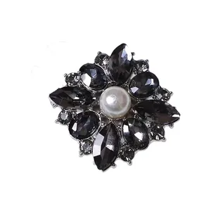 Elegant vintage flower brooch featuring a central pearl and grey gemstones on silver base