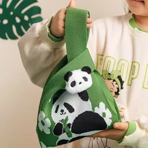 Detailed knit texture of green panda tote bag with plush charm and woven panda pattern