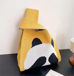 Close-up of yellow knit panda bag with thick texture and Japanese knot handle design