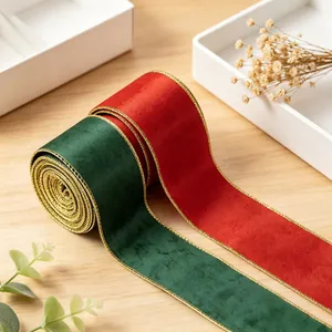 Close-up of 6cm red and green velvet ribbons with gold edges on wooden surface