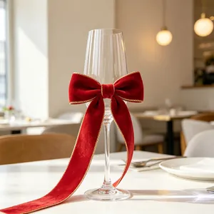 Elegant champagne glass with festive red velvet bow and gold trim in a warm restaurant setting