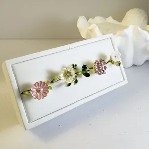 Detalle del set de anillos florales bañados en oro con margaritas y perlas