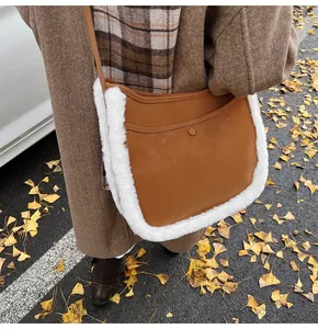 Close-up of caramel suede bucket bag with white faux fur trim in an autumn setting