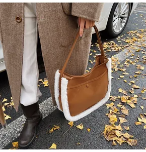 Brown suede bucket bag with white faux fur trim shown in a seasonal autumn street setting