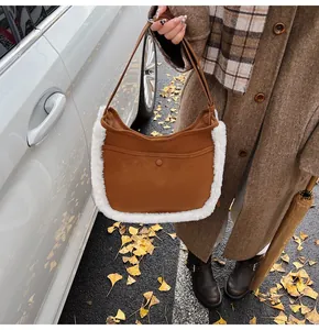 Outdoor shot of a brown faux suede bucket bag with white plush trim and shoulder strap
