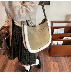Detail of khaki suede bucket bag with plush faux fur trim on a female model