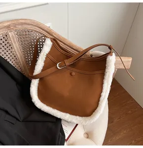 Detail of suede bucket bag with white faux fur trim and adjustable leather shoulder strap