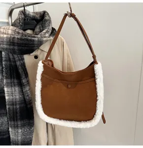 Detail view of brown suede bucket bag with plush faux fur trim and snap button pocket