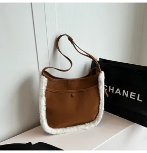 Detail view of brown faux suede bucket bag with soft plush trim and adjustable strap