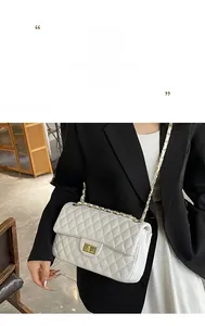 Detailed view of white quilted leather bag with gold clasp and chain strap