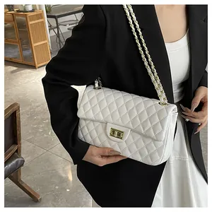 Close-up of elegant white quilted shoulder bag with gold metal twist lock and chain strap