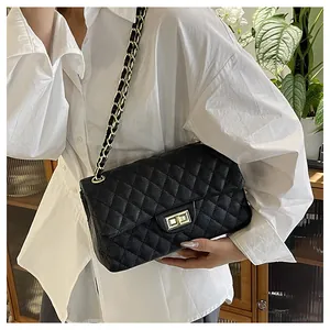 Classic black quilted shoulder bag with gold twist lock on model in a stylish interior