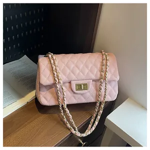 Detailed view of pink quilted leather bag with gold chain strap and twist lock closure
