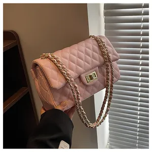 Detailed view of pink quilted leather handbag with gold twist lock and chain strap