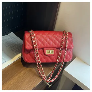 Detail view of the red quilted leather chain bag with golden metal twist-lock buckle